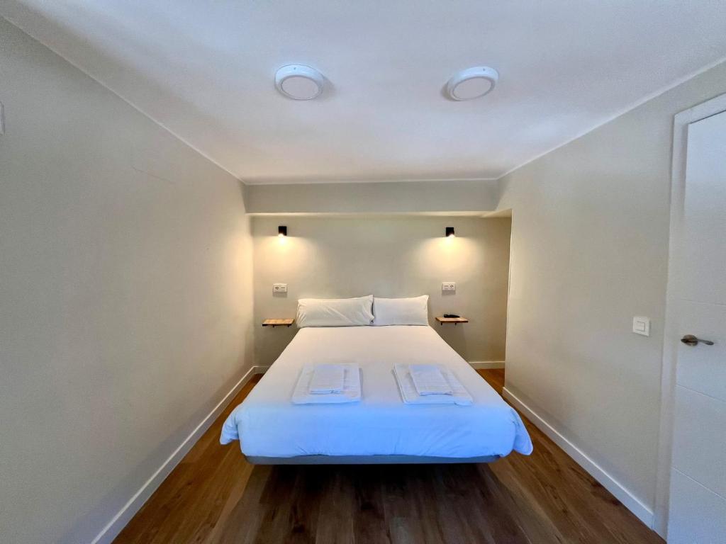 um quarto com uma grande cama branca num quarto em Hostal Mindanao em Salamanca