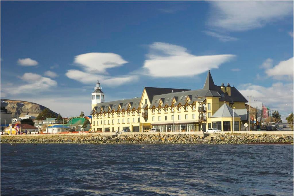 a large building with a lighthouse on top of it at Hotel Costaustralis in Puerto Natales