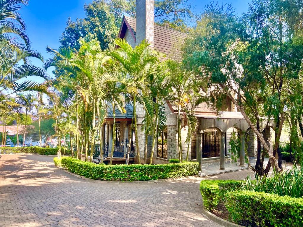 a house with palm trees in front of it at Wenzi Luxury Home in Arusha