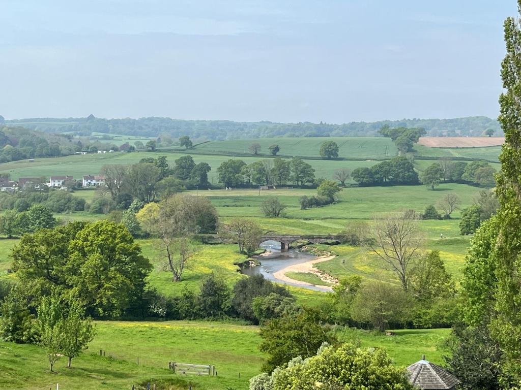 a view of a green field with a river at Otter Holt, beautiful East Devon in Tipton Saint John
