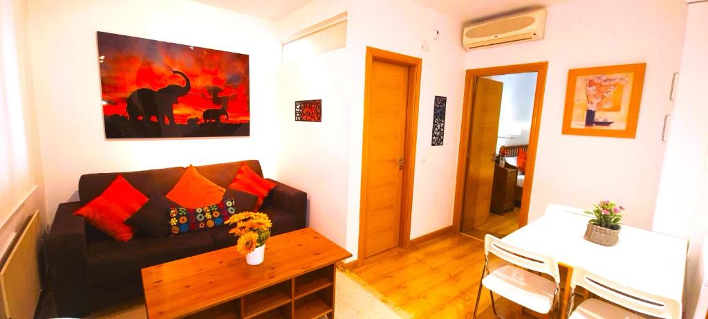 a living room with a couch and a table at Gran Via Alaia Seasonal Living in Madrid