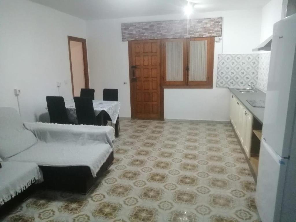 ein Wohnzimmer mit Stühlen und einem Tisch sowie eine Küche in der Unterkunft Señora Isabel in Roquetas de Mar