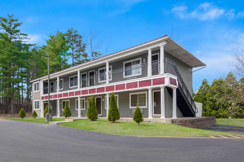 a white and red house on a street at Quality Inn in Queensbury