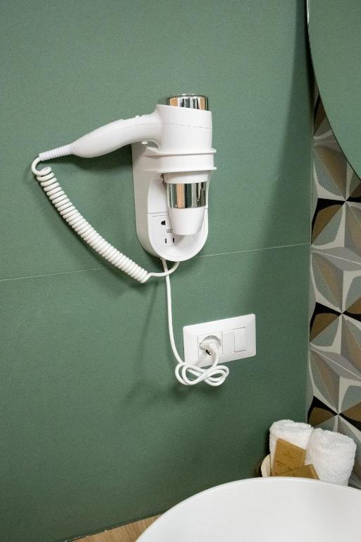 un telefono bianco su una parete verde accanto a un water di Bari in un click a Bari