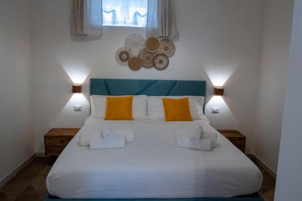 una camera da letto con un grande letto bianco con cuscini gialli di Bari in un click a Bari