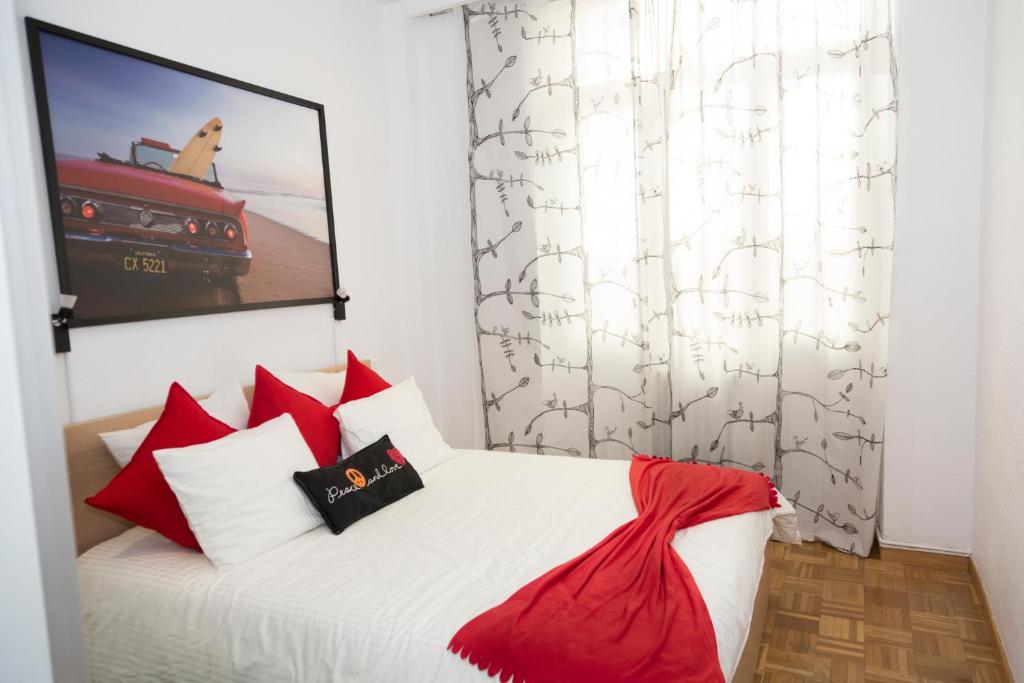 マドリードにあるGran Viaのベッドルーム1室(赤と白の枕が備わるベッド1台付)