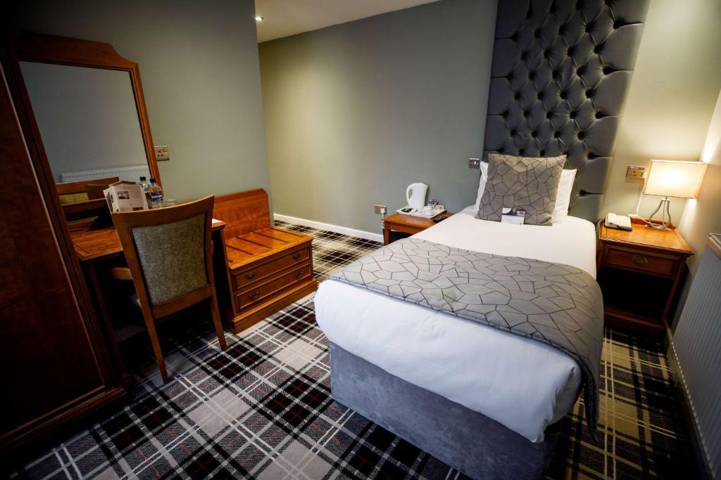 a bedroom with a bed and a desk and a mirror at Heritage Park Pontypridd, Trademark Collection by Wyndham in Pontypridd