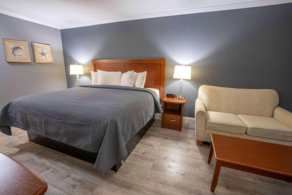 um quarto de hotel com uma cama e uma cadeira em All Seasons Resort, Trademark Collection by Wyndham em South Yarmouth