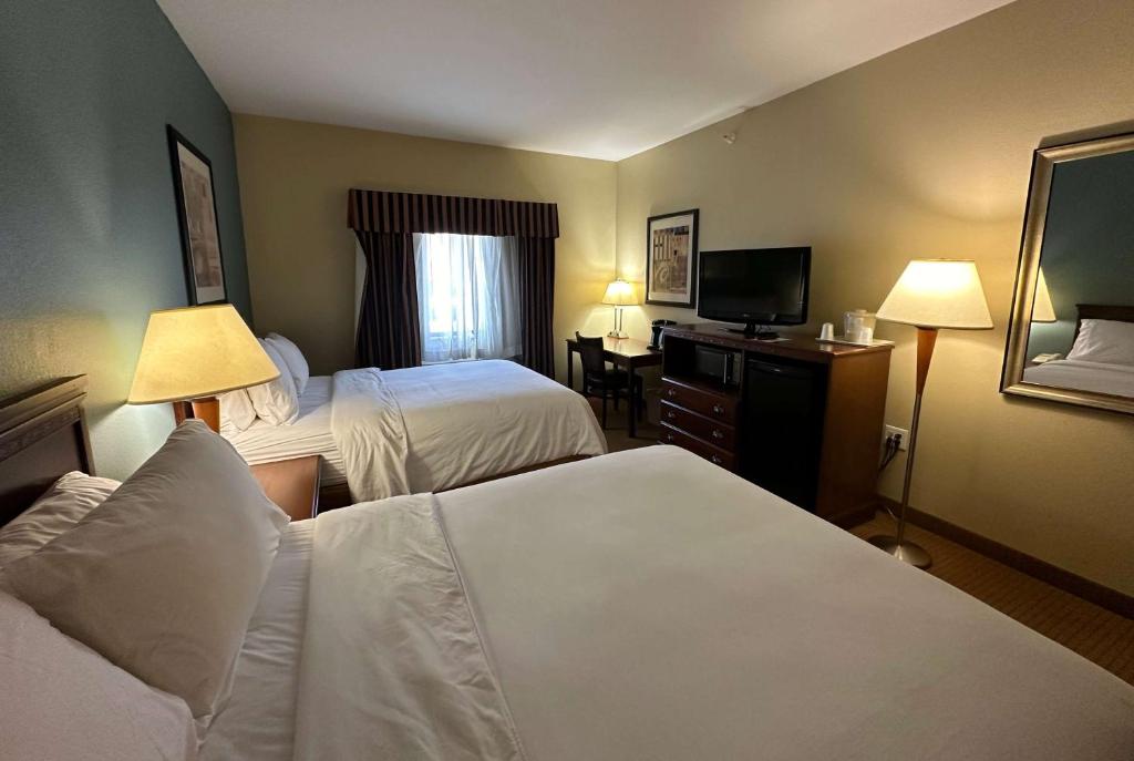 a hotel room with two beds and a television at Wingate by Wyndham Newell in Newell