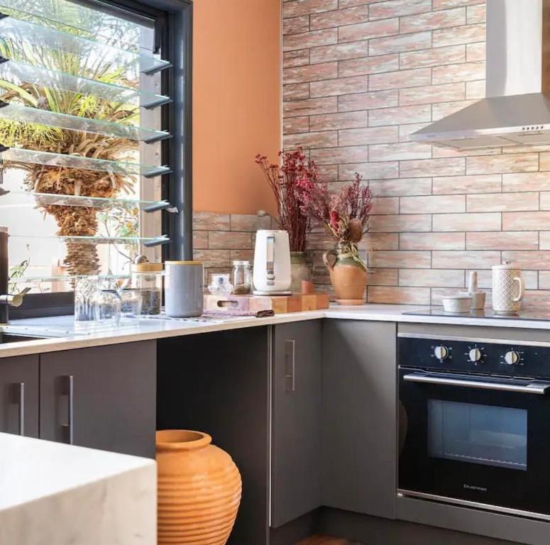a kitchen with a counter with a stove top oven at Relaxing Burleigh Heads Home with Swimming Pool in Gold Coast