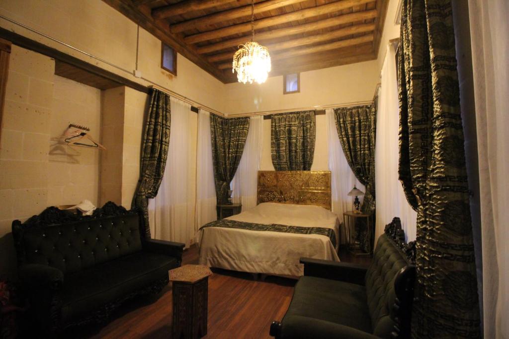 a bedroom with a bed and a couch and a chair at aynur hanım konağı butik otel in Şahinbey