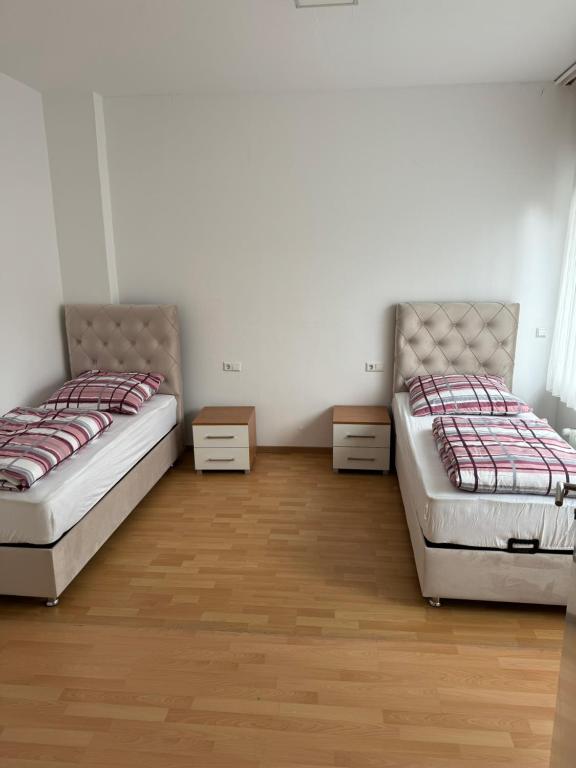 Duas camas num quarto com pisos em madeira em Pension - Panorama em Gundelsheim
