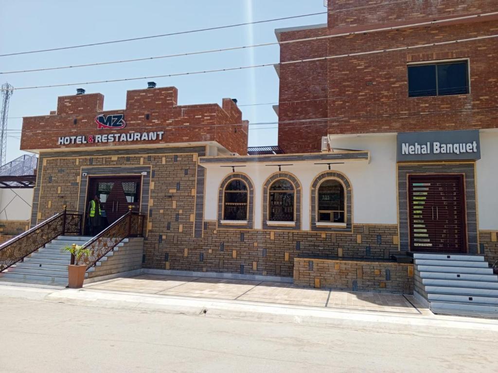 a brick building with a main entrance and stairs at MZ Hotel and Restaurant Sukkur in Kalar Goth