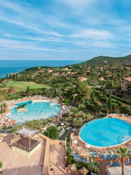 - une vue aérienne sur deux piscines d'un complexe dans l'établissement Magnifique appartement vue mer avec piscine, à Saint-Raphaël