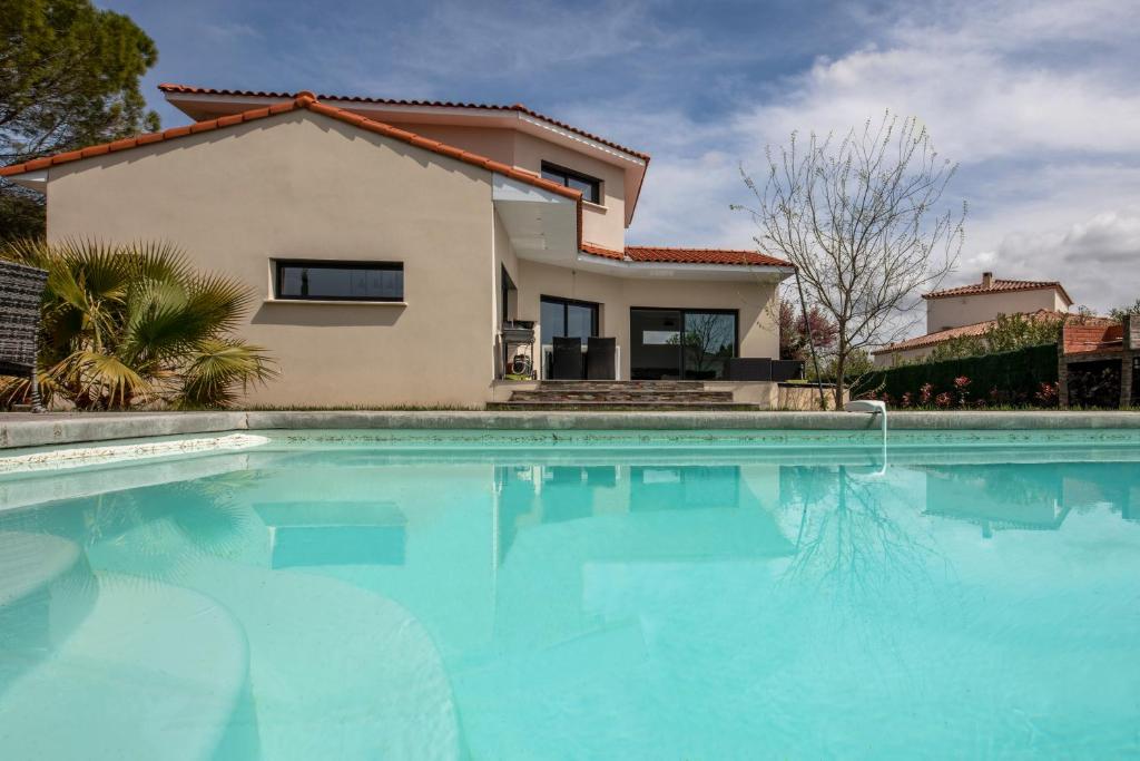 une maison avec une piscine devant une maison dans l'établissement Villa micocouliers, à Combaillaux