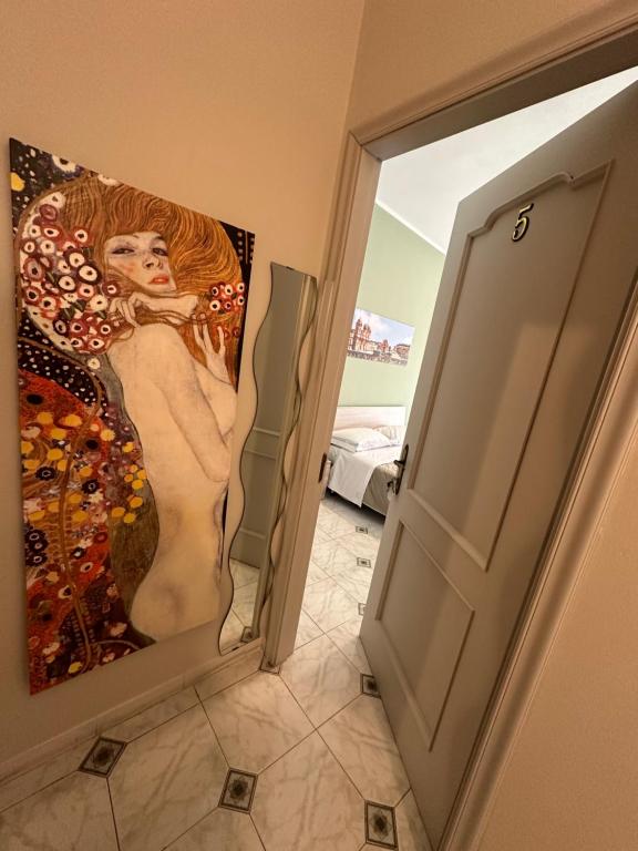 Un dipinto di una donna su un muro accanto a una porta di La Madonnina a Noto