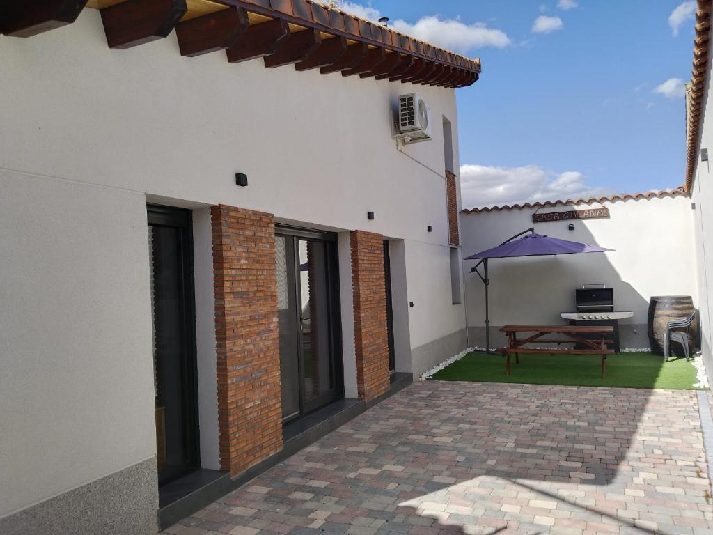 的住宿－Casa galana，一座带桌子和紫色雨伞的庭院