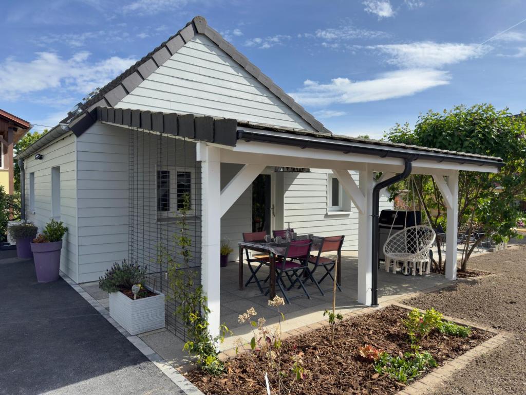 une pergola blanche avec une table dans la cour dans l'établissement Gîte Les Lilas, centre Alsace, avec jacuzzi, à Mackenheim