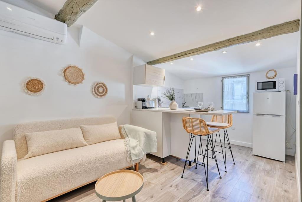 uma sala de estar com um sofá e uma cozinha em nid douillet près du vieux port em Marselha