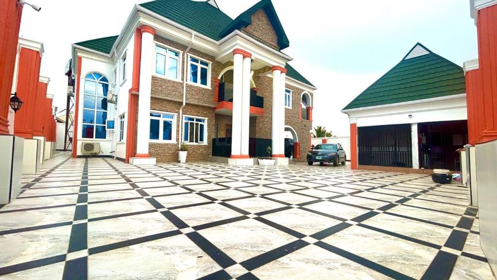 una casa grande con una entrada delante de ella en 001 Apartments, en Oshogbo