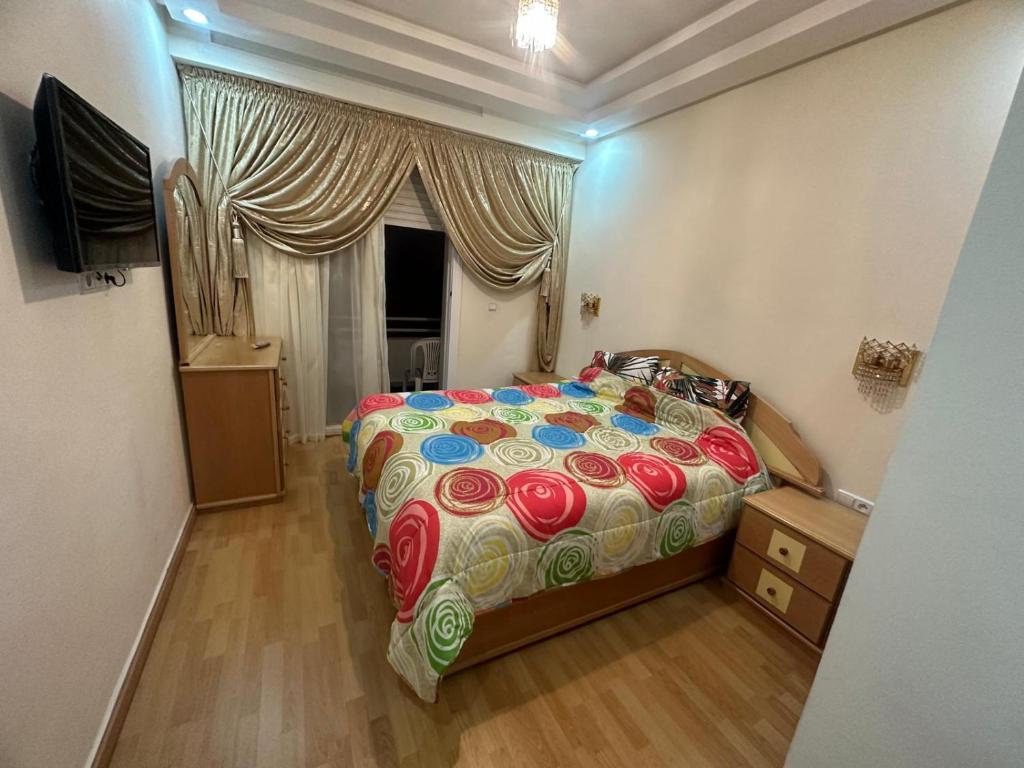 - une chambre avec un grand lit et une fenêtre dans l'établissement Appartement familial agadir, à Agadir