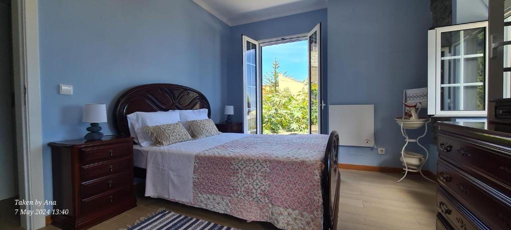 a blue bedroom with a bed and a window at Casa do Amigo in Seixal