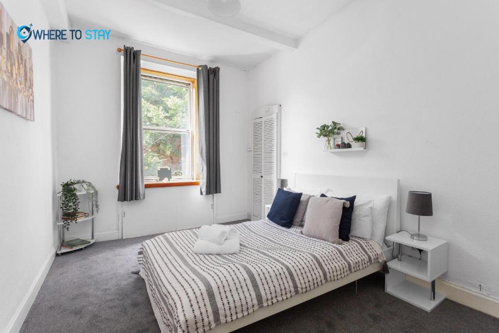 - une chambre blanche avec un lit et une fenêtre dans l'établissement 2 Bed Apartment - 7 min walk Train Station, à Édimbourg