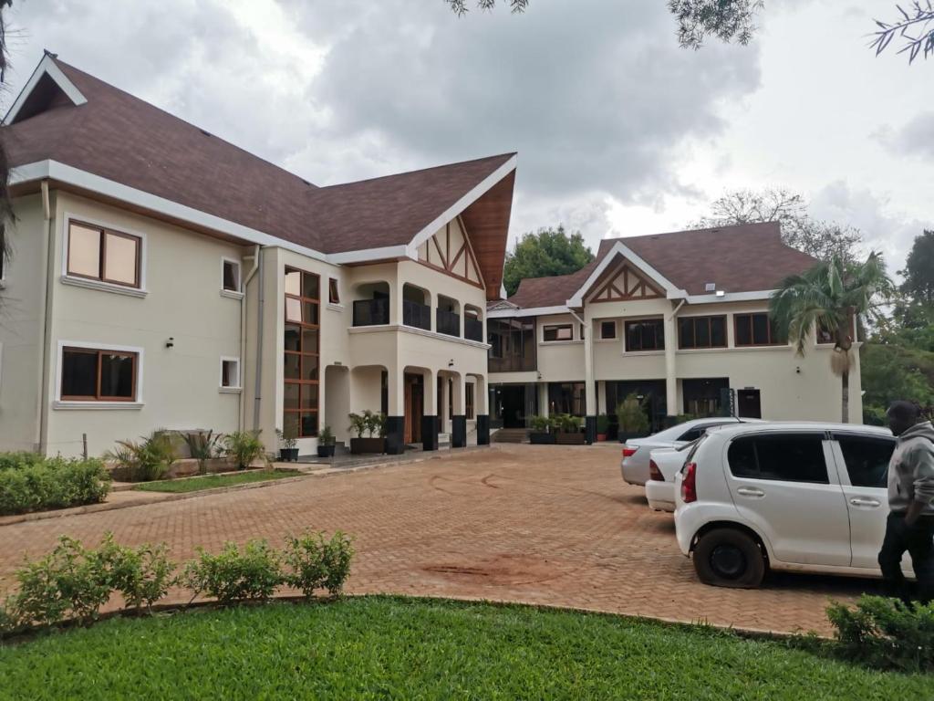 un hombre se para delante de una casa en HAVEN STAY HOTEL, en Eldoret