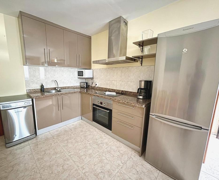 a large kitchen with stainless steel appliances in at CASA LORENZO in the center in Playa Blanca