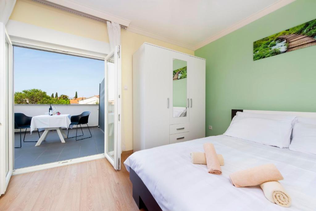 1 dormitorio con 1 cama y balcón con mesa en Apartments Sena, en Rovinj