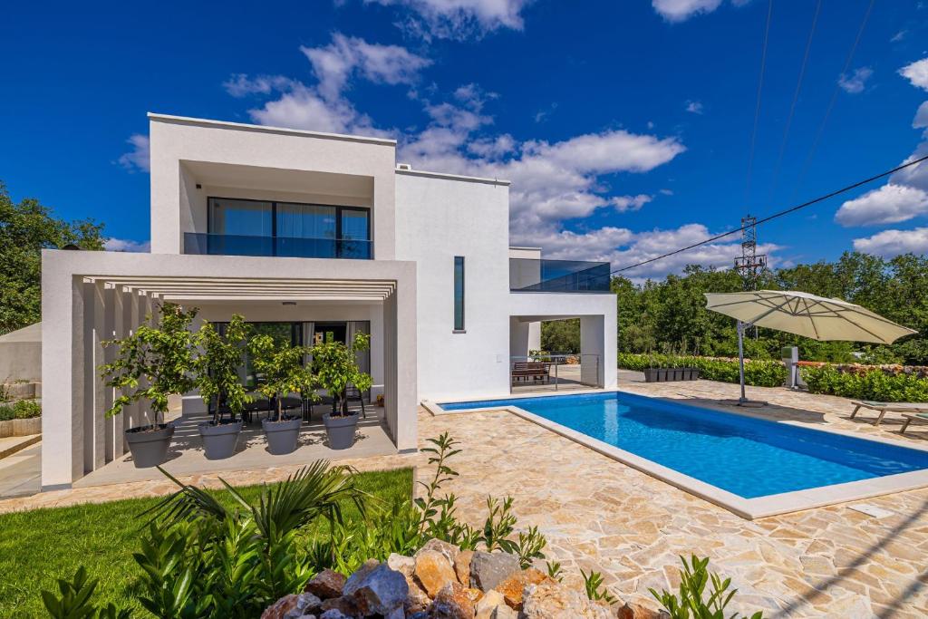 a villa with a swimming pool and a house at Villa SPLENDIDA in Žgaljić