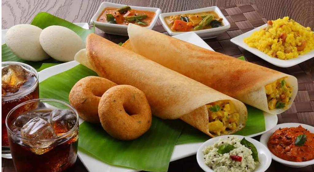 un plato de comida con un sándwich y aros de cebolla en IInfinity Kodaikanal en Kūkkāl