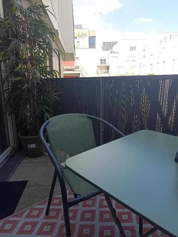 une table et une chaise sur un balcon dans l'établissement Studio tout confort Massy-Paris, à Massy