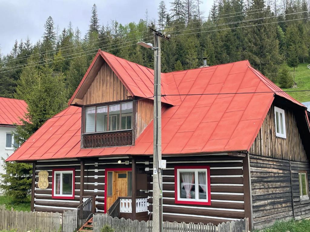 ein Holzhaus mit rotem Dach in der Unterkunft Drevenica 66 in Ždiar