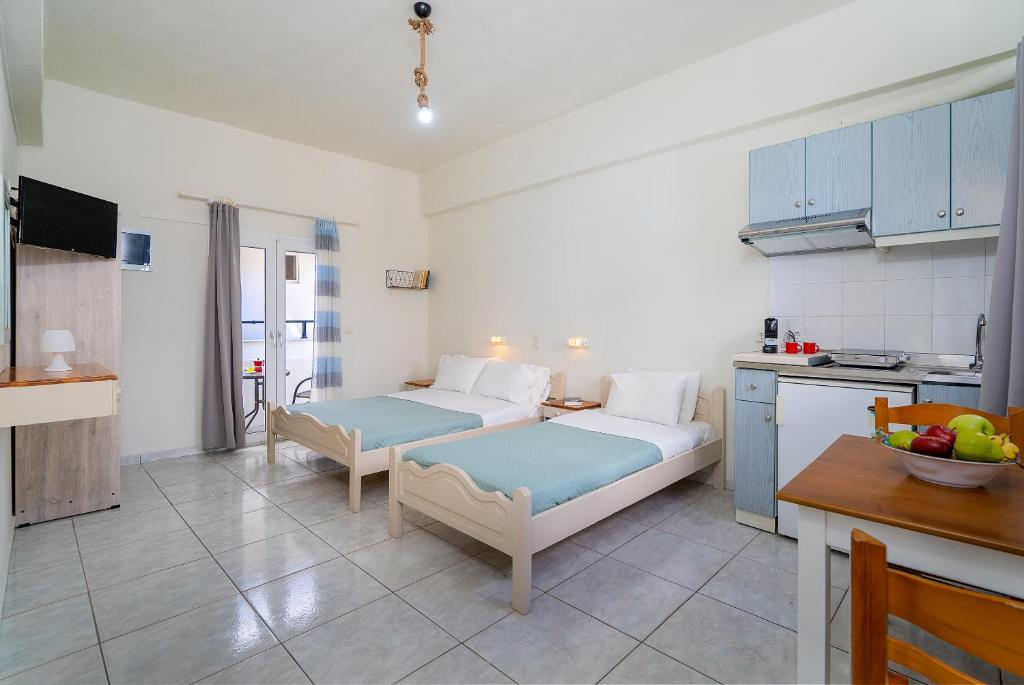 uma sala de estar com 2 camas e uma cozinha em Giant Woman em Tsoutsouros