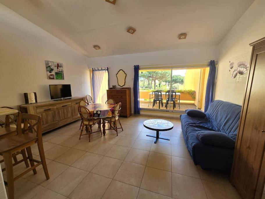 un salon avec un canapé bleu et une table dans l'établissement Cap d'Agde proche port et plage, au Cap d'Agde