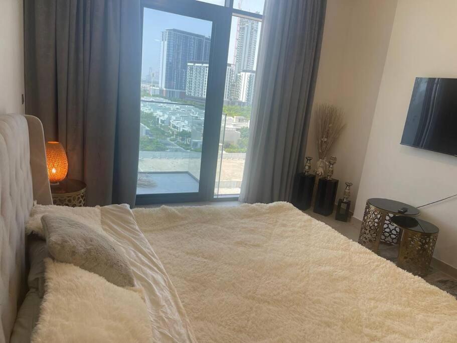 a bedroom with a bed and a large window at Luxury Studio l Burj Khalif View in Dubai