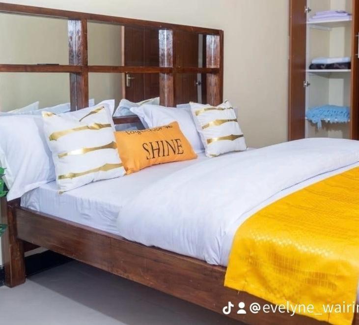 a bed with white sheets and pillows on it at Thika Furnished Apartments in Thika