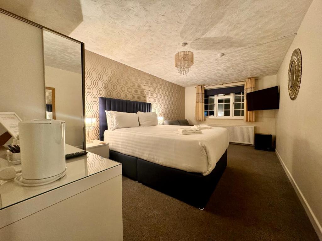 a bedroom with a large bed and a mirror at Marina Court in Weymouth