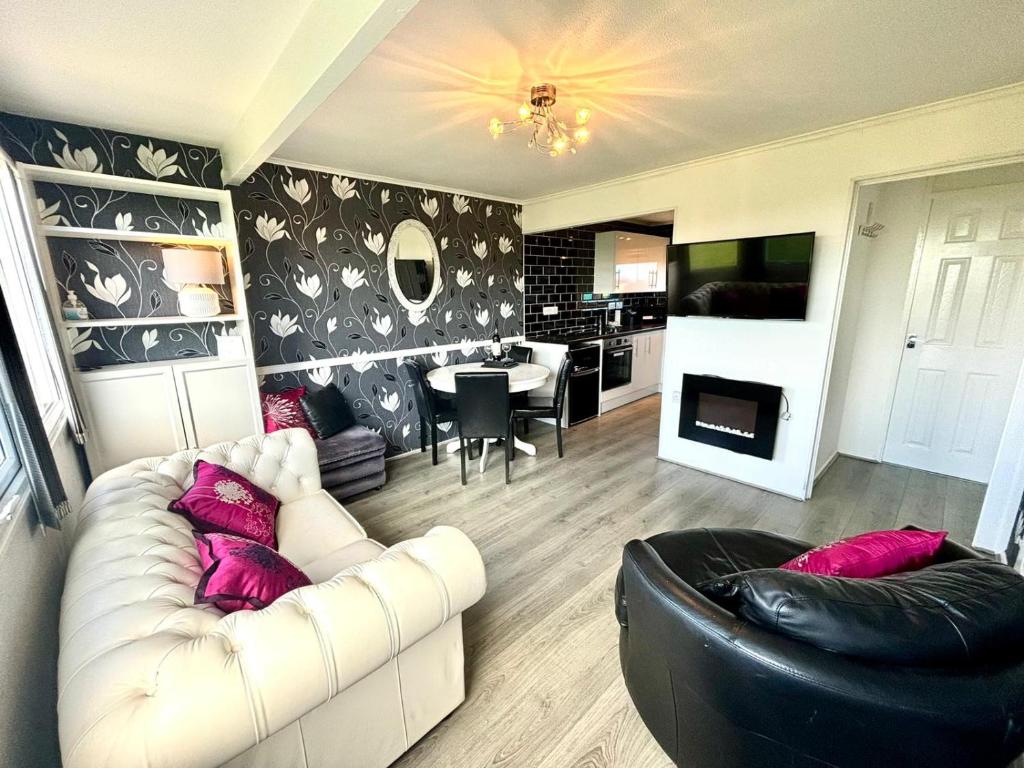 a living room with a white couch and a table at Family Chalets - 5 mins walk to beach, nr Great Yarmouth & Norfolk Broads in Scratby