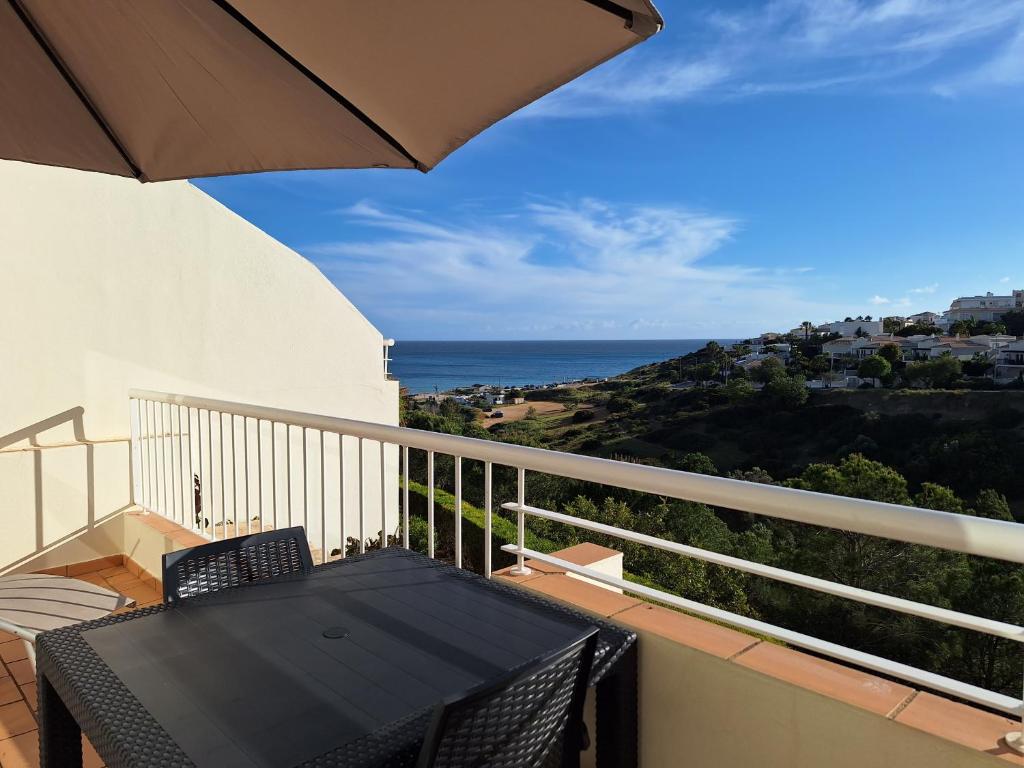 a balcony with an umbrella and a view of the ocean at Vila Apostol in Lagos