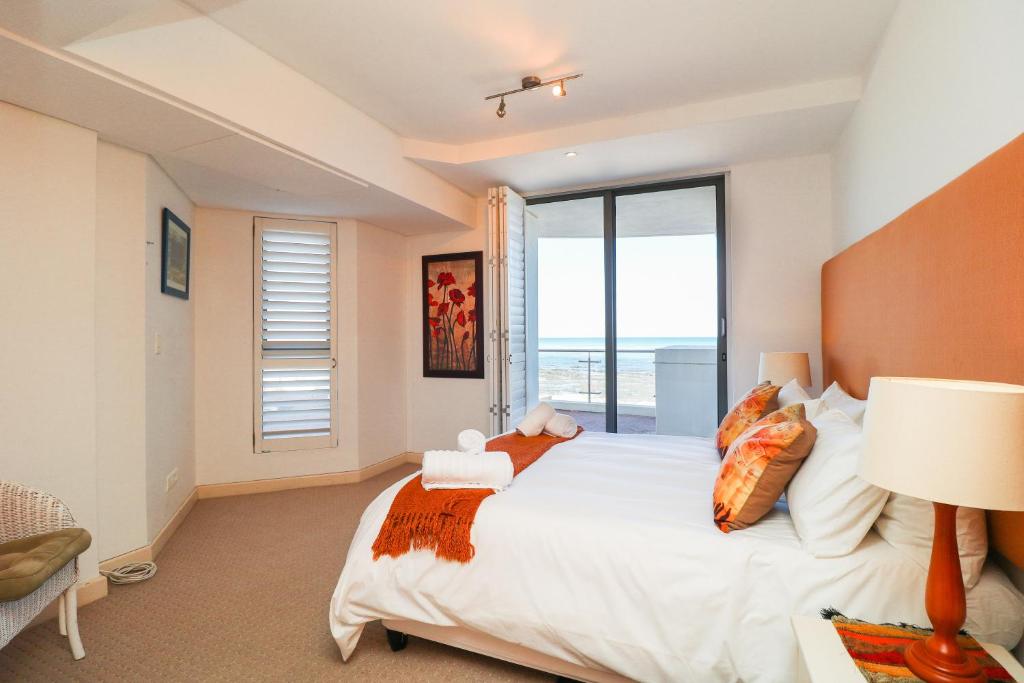 a bedroom with a large bed and a large window at 506 Hibernian Towers Luxury Self Catering Apartment Strand Cape Town South Africa in Cape Town