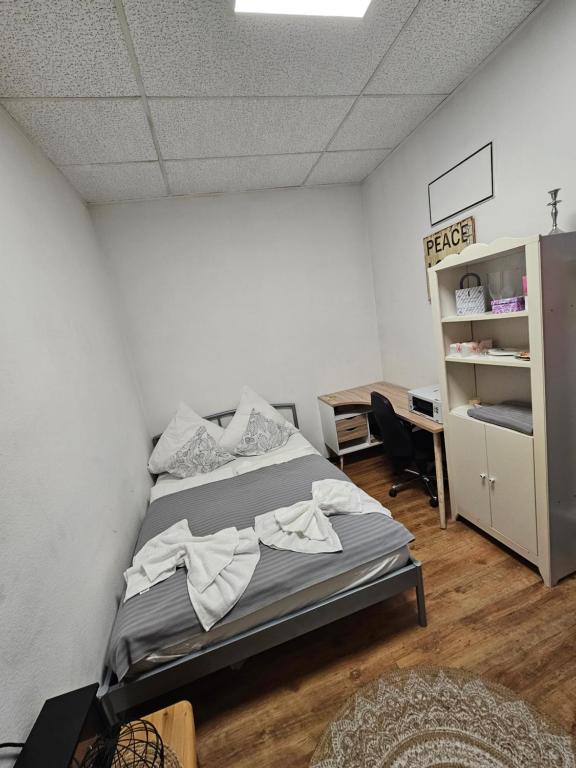 een slaapkamer met een bed, een bureau en een plank bij Apartment 3 UG La Paula in Stein bei Nürnberg