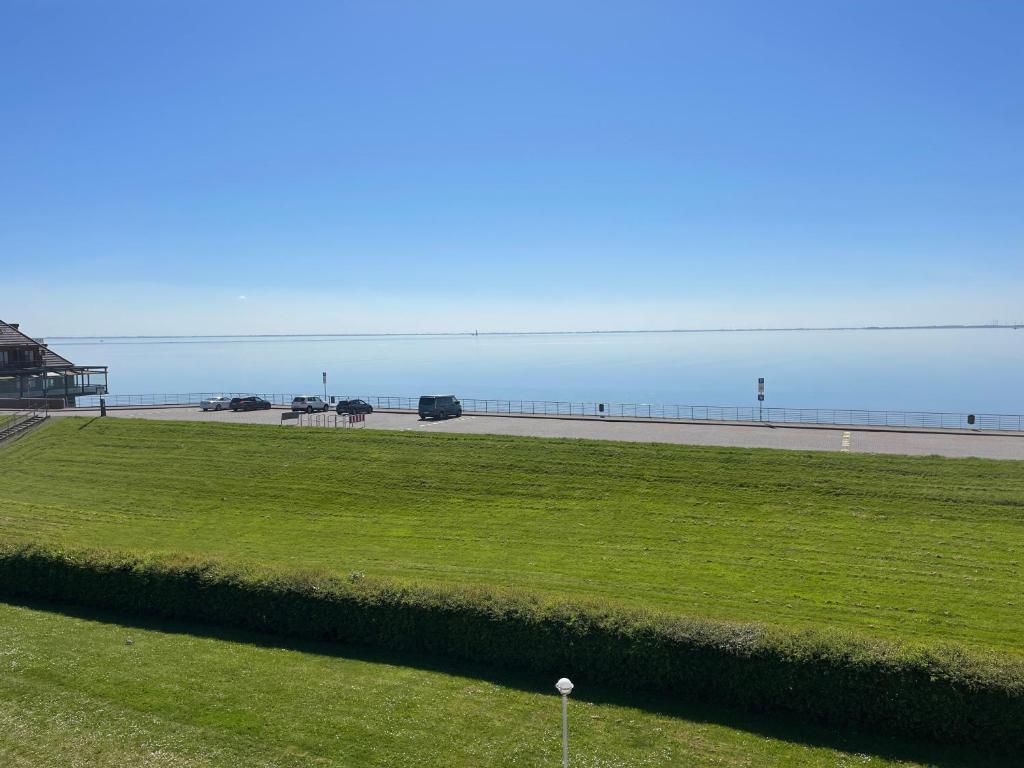 een grasveld met een strand op de achtergrond bij Apartment 123 in Wilhelmshaven