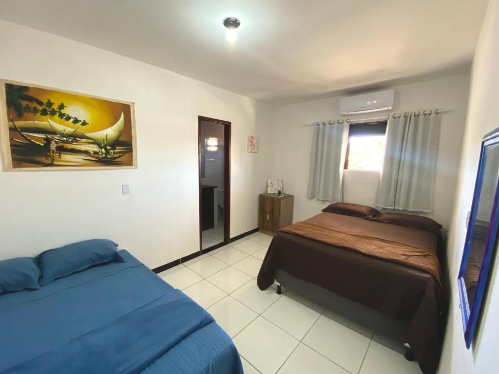 een slaapkamer met 2 bedden en een raam erin bij SANNY Pousada e Hostel in Pipa