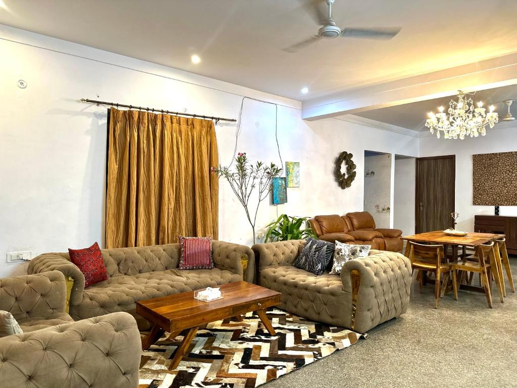 een woonkamer met banken en een tafel en een eetkamer bij 3 BHK entire villa near Medanta hospital in Gurgaon