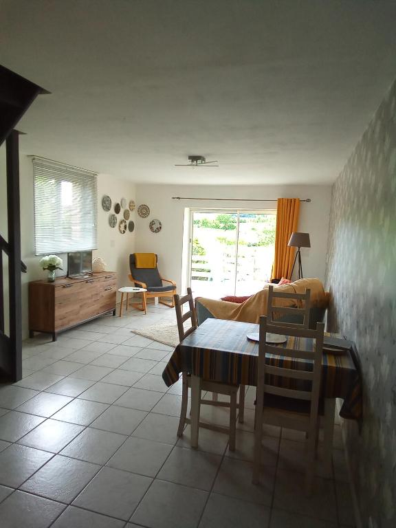 a living room with a table and chairs and a couch at Modern one bedroom cottage in Saint-Mandé-sur-Brédoire