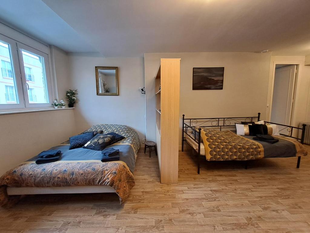um quarto com duas camas e um sofá em Le Horsier em Dieppe