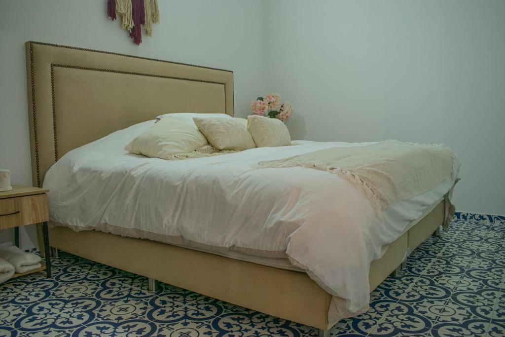 Eco Apartamento Crudo في خاردين: سرير عليه وسادتين في غرفة النوم