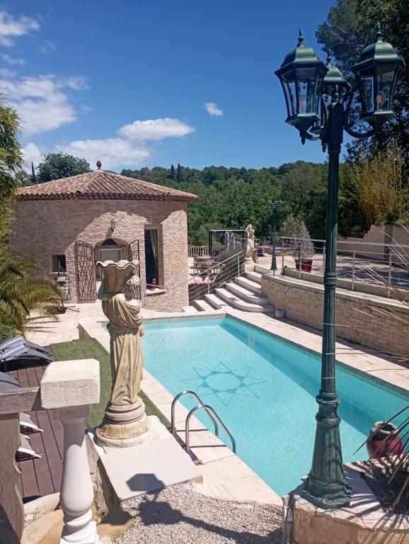 una statua di un gatto è accanto a una piscina di French Riviera Gaudissard a Vence
